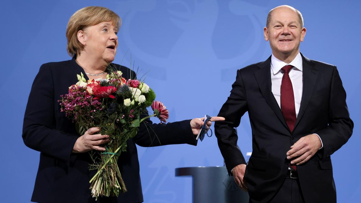 La ex canciller alemana Angela Merkel sostiene flores mientras entrega la cancillería a su sucesor, el recién nombrado canciller alemán Olaf Scholz en la Cancillería en Berlín, Alemania, el 8 de diciembre de 2021.