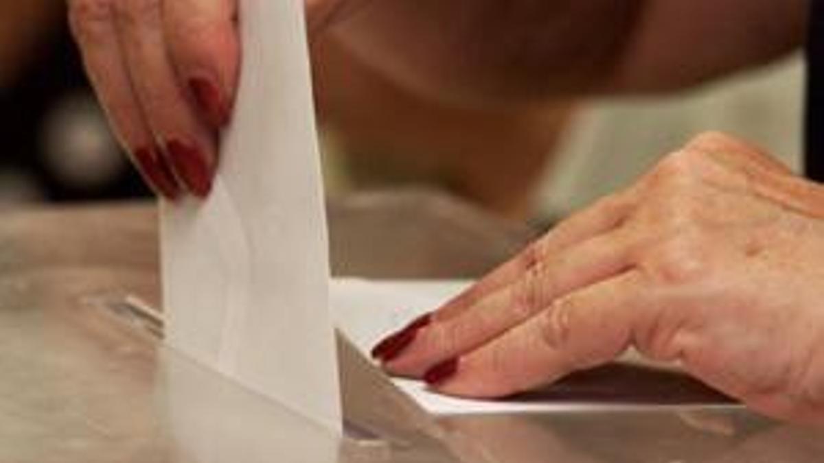 Unha muller deposita o voto nunha urna
