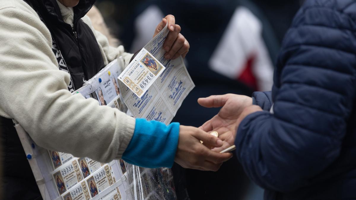 Una persona compra Lotería de Navidad.