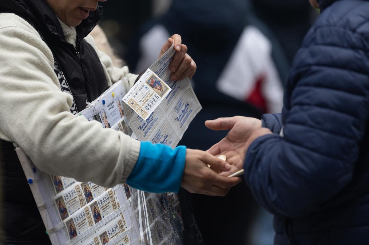 Una persona compra Lotería de Navidad