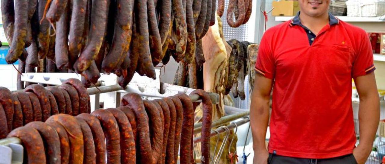 Félix García Álvarez con varios embutidos artesanos en la carnicería familiar de Belmonte.