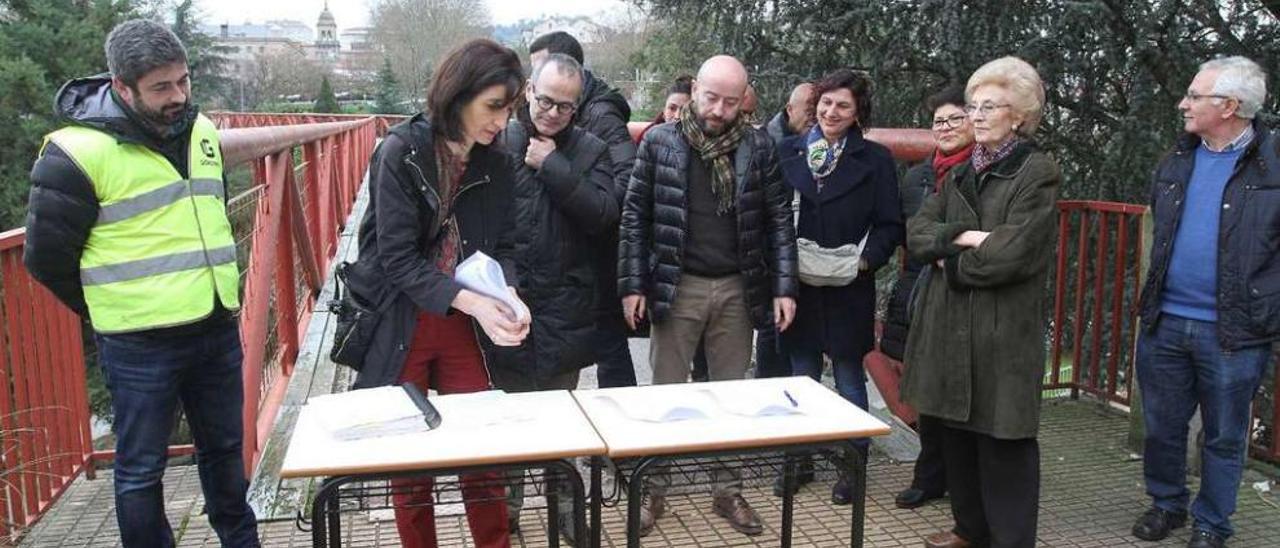 El alcalde Jesús Vázquez y vecinos de la zona, en la firma del acta de replanteo para las obras en la pasarela sobre el Barbaña. // Iñaki Osorio