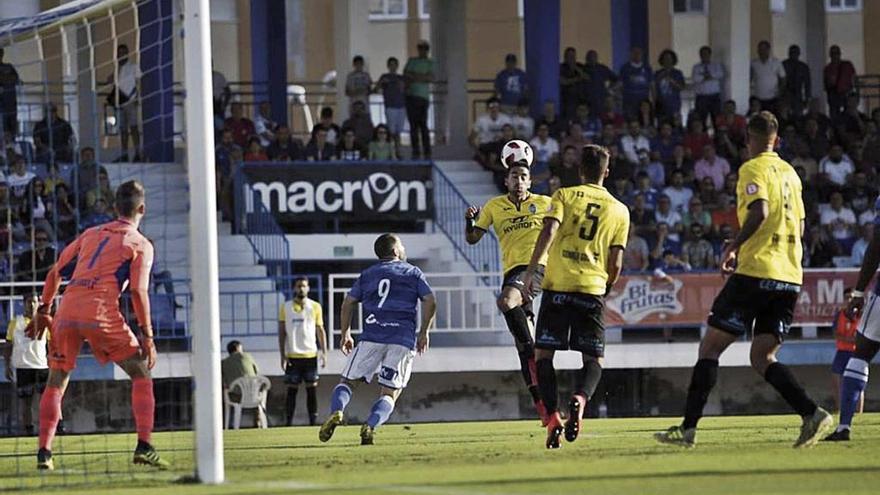 La defensa del Atlético Baleares despeja un balón del Melilla al corazón del área, ante la atenta mirada de Carl Klaus.