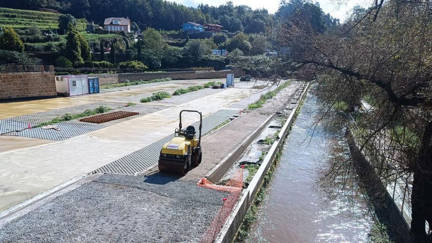 Obras del nuevo aparcamiento disuasorio de Vilavella junto al cauce del río Maceiras, ayer.  // A.P.