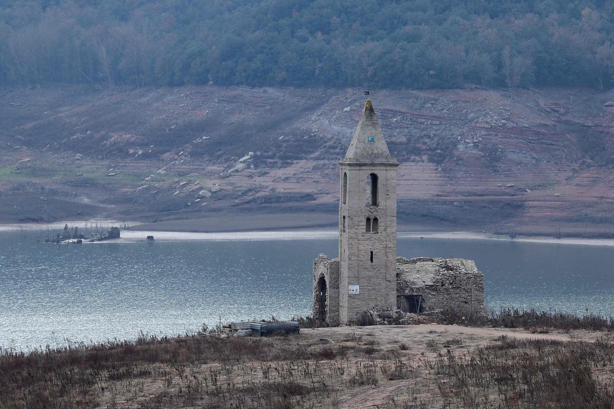 Esta fotografía tomada el 15 de enero de 2024 muestra la iglesia de Sant Roma de Sau en la orilla del estiaje del embalse de Sau, situado en la provincia de Girona en Cataluña. Cataluña lucha contra una sequía histórica desde hace tres años y algunos residentes ya experimentan restricciones de agua en su vida diaria.