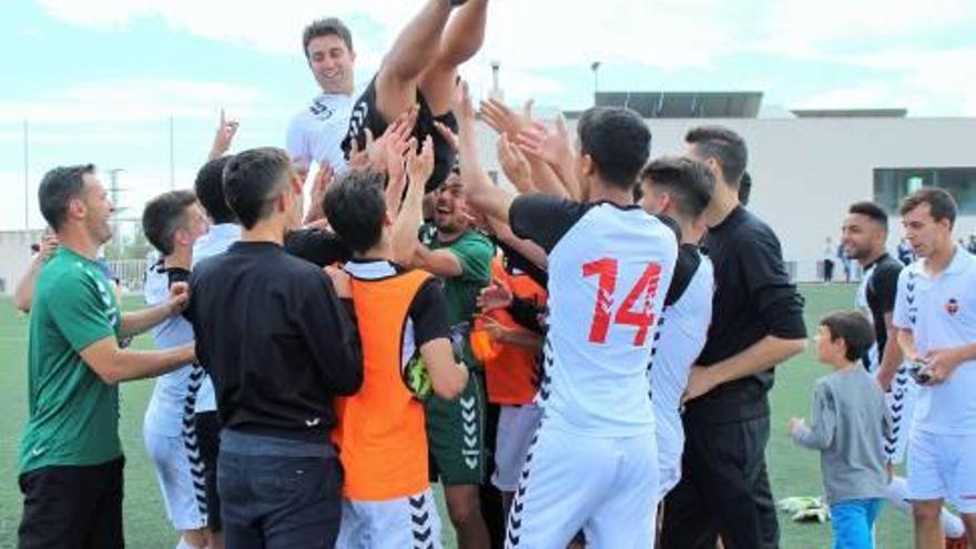 Jugadores y cuerpo técnico mantean al joven mister Aitor García.