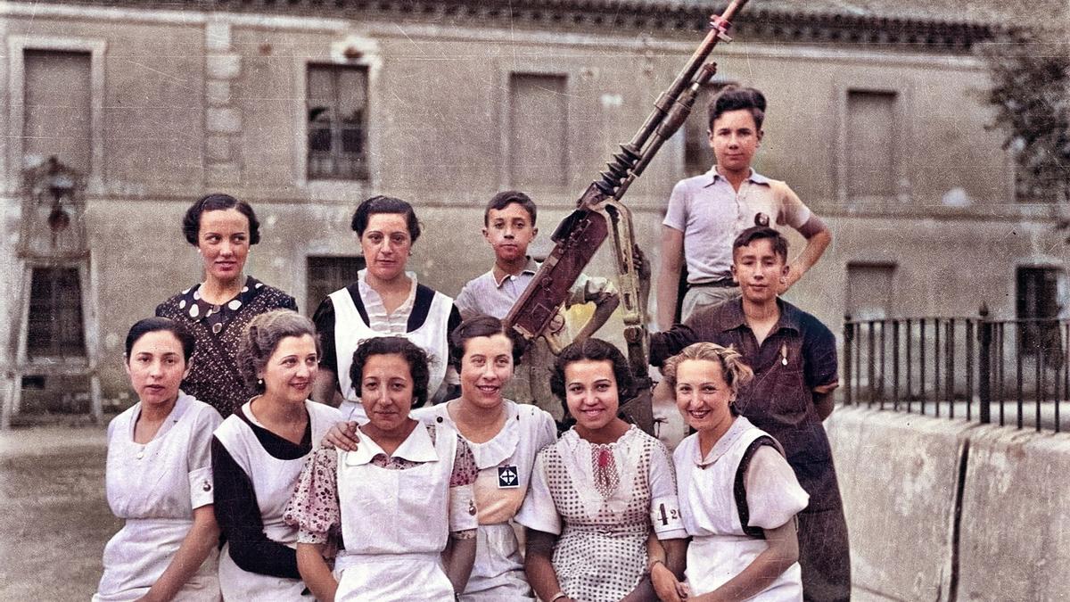 Enfermeras y niños posan en el Hospital Provincial junto a una ametralladora para defensa antiaérea contra las FARE, en 1938.