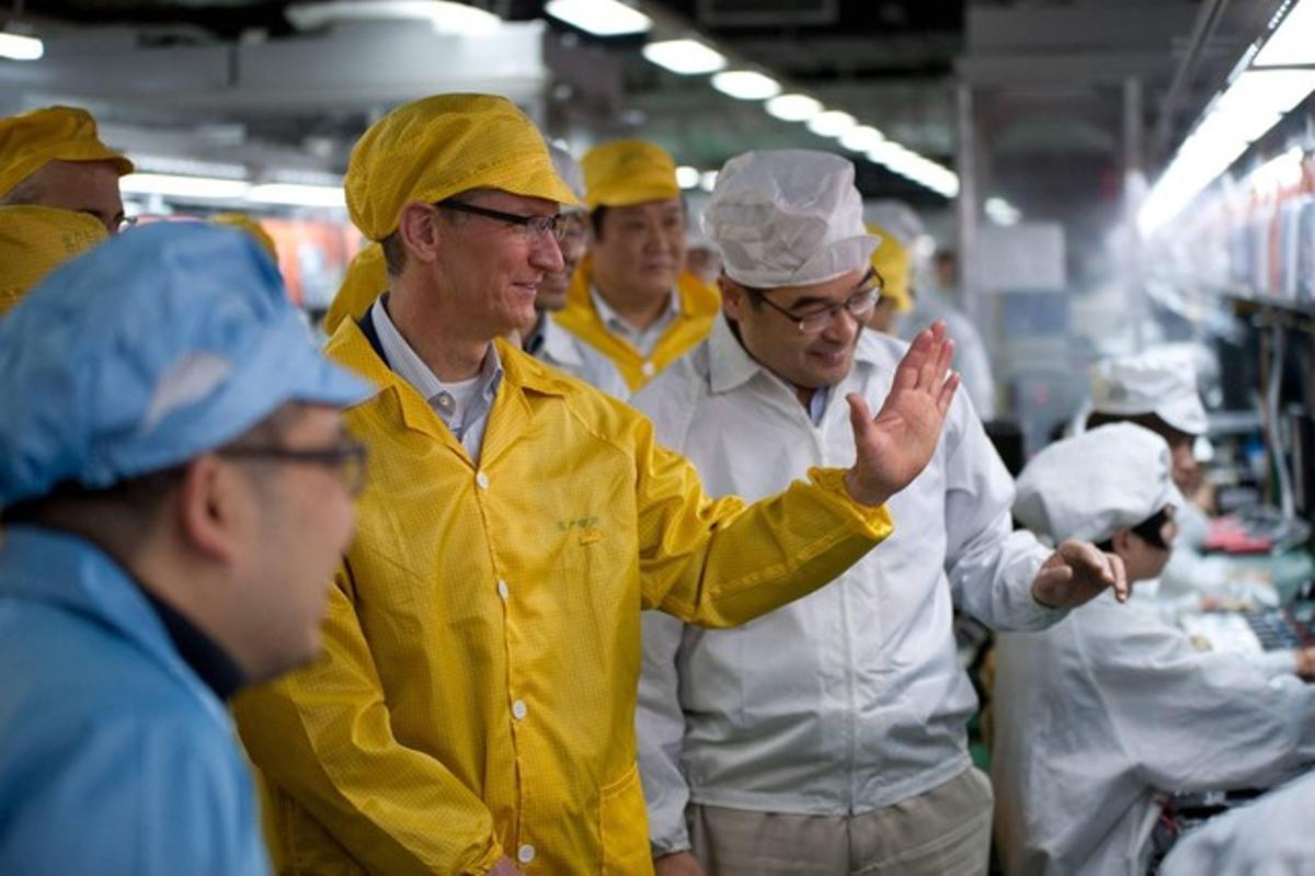Tim Cook (en primer terme, de groc), conseller delegat d’Apple, durant una visita a una factoria de Foxconn a Henan (Xina), el març passat.