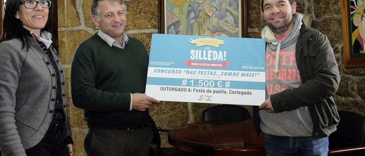 Premio en Silleda por su plan de empadronamiento   |  El alcalde de Silleda, Manuel Cuiña, y la edil de Turismo, Ana Luisa González, entregaron ayer a Román Peña el premio de 1.500 euros correspondiente a un concurso de la campaña de empadronamiento En Silleda somos máis. Peña es miembro de la asociación sociocultural de Cortegada, organizadora de la Festa da Paella de la parroquia. De cara a la campaña de este año el alcalde avanzó una modificación en las bases del certamen, que duplicará su dotación económica para premios. Así, se establecerá un primero de 1.500 euros, un segundo de 1.000 y un tercero, de 500 euros. Las bases está previsto que se den a conocer en las próximas semanas.