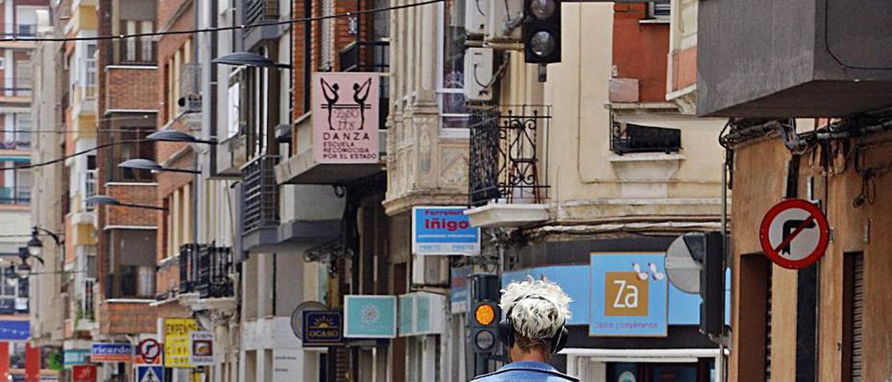 Un joven circula con cascos en un patín por Alzira. | V. M. PASTOR