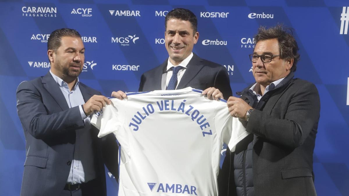 Cordero, Velázquez y Sanllehí sujetan a pie de campo una camiseta con el nombre del técnico.