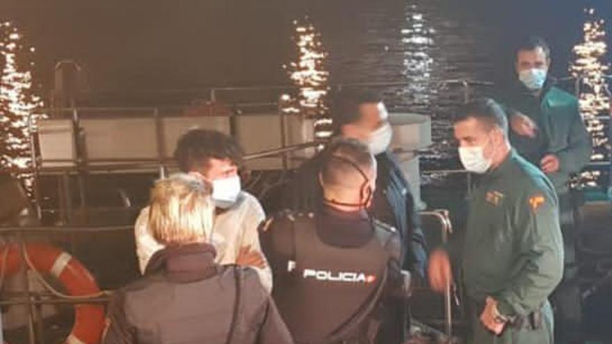 Uno de los detenidos que saltó al mar, rodeado de agentes de la Guardia Civil y de la Policía Nacional. / Policía Nacional