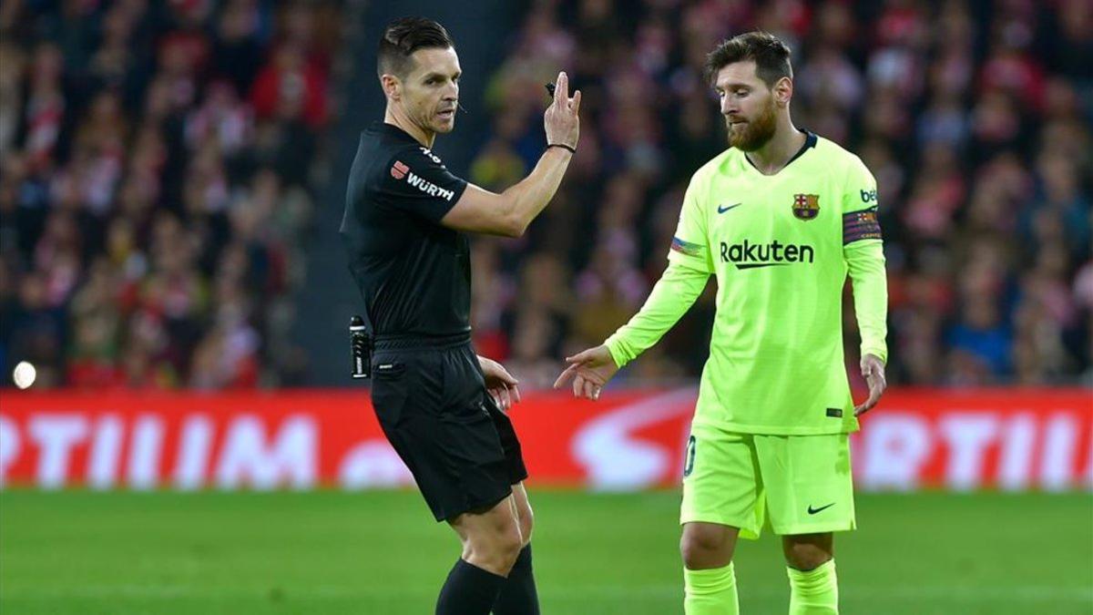 El árbitro Carlos del Cerro Grande junto a Leo Messi durante un encuentro