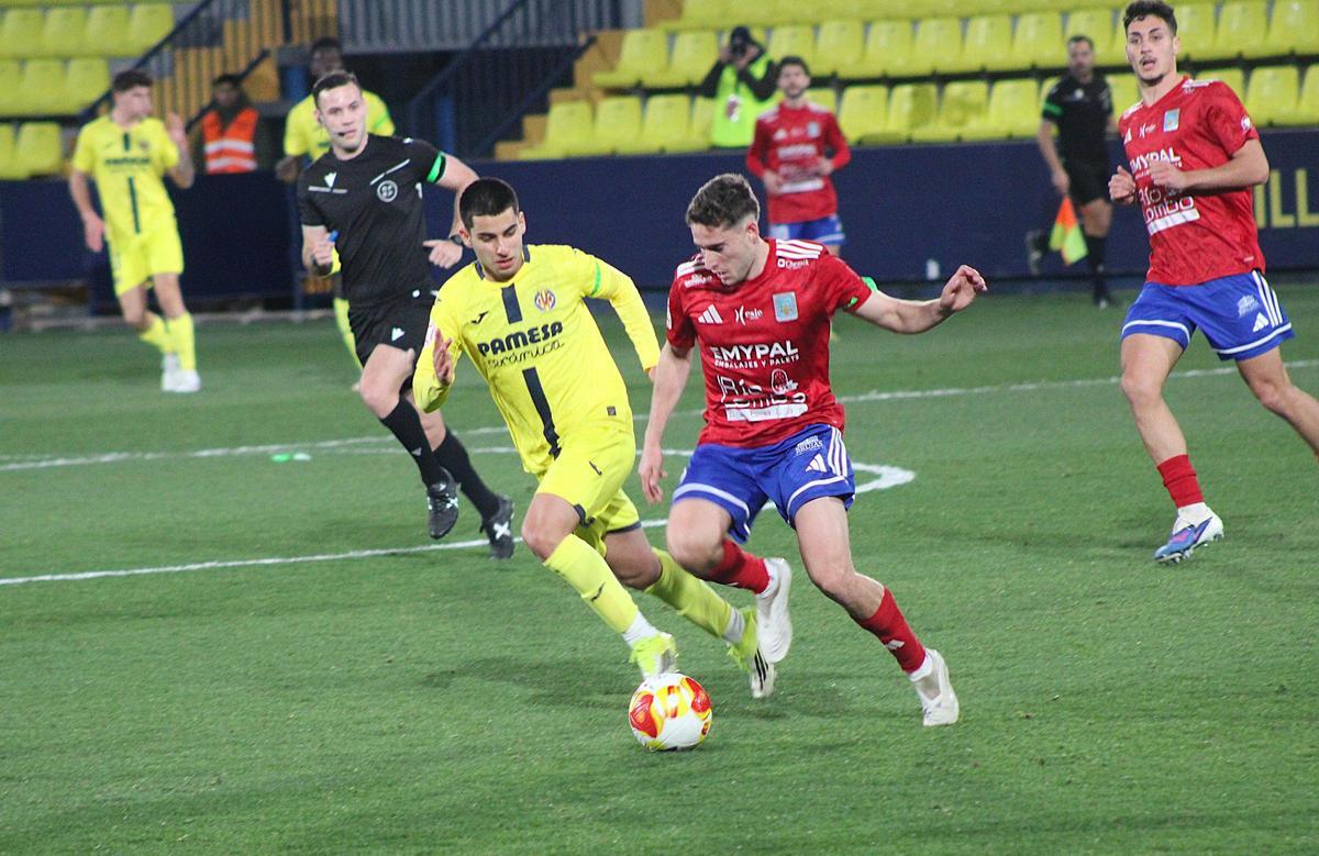 Joselillo Gaitán, muy activo todo el partido, pelea un balón en el centro del campo contra un rival.