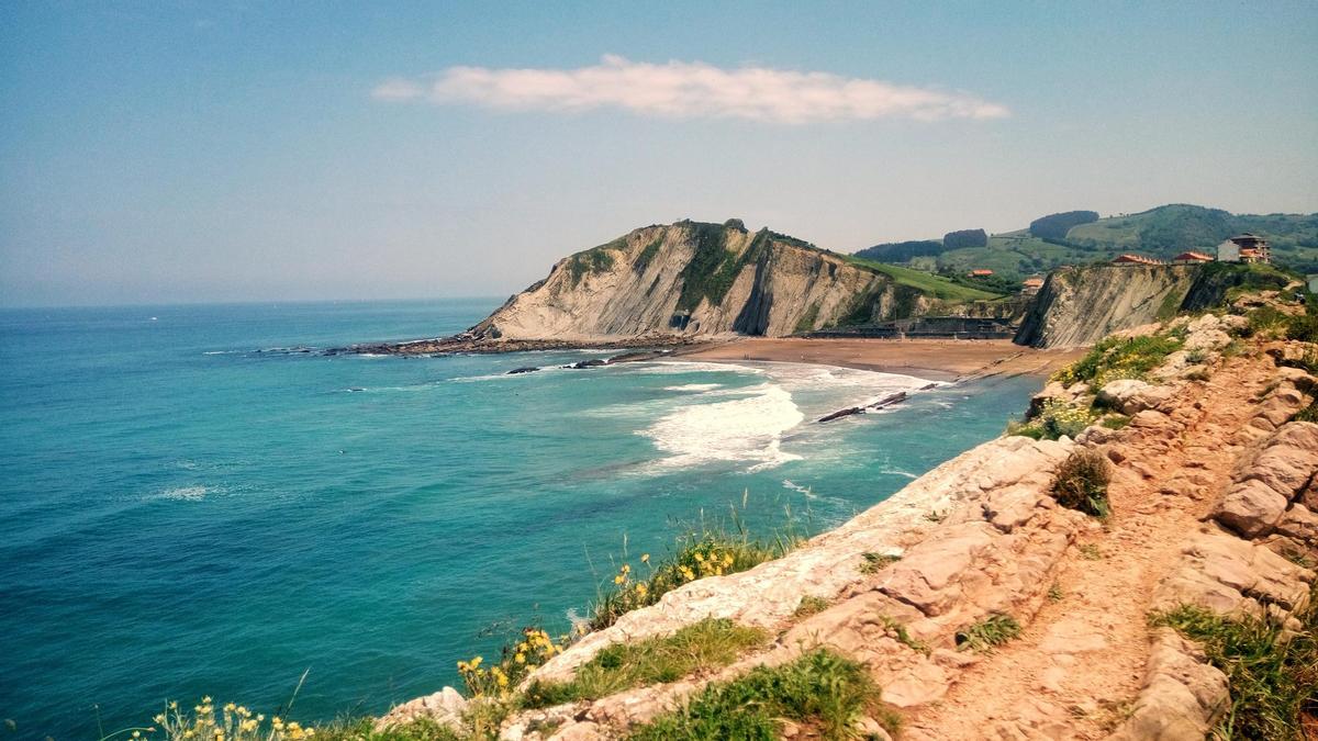 Vista panorámica de la playa de Itzurún con formaciones geológicas flysch y acantilados en Zumaia