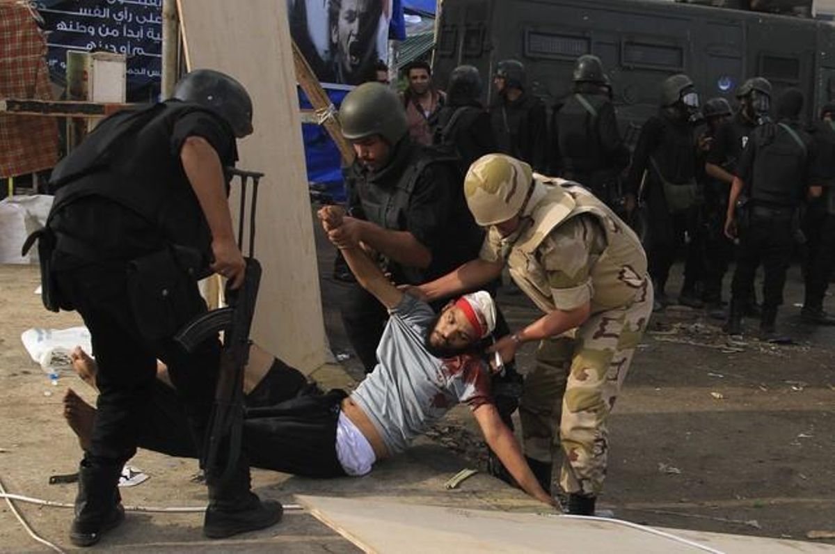 Policies antiavalots i un soldat atenen un manifestant ferit.