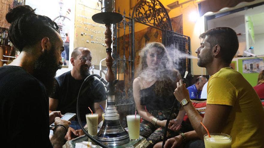 Un grupo fuma cachimba en uno de los locales del centro de Málaga.