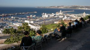 Archivo - Un grupo de personas observa desde lo alto el puerto de Tánger, en Marruecos