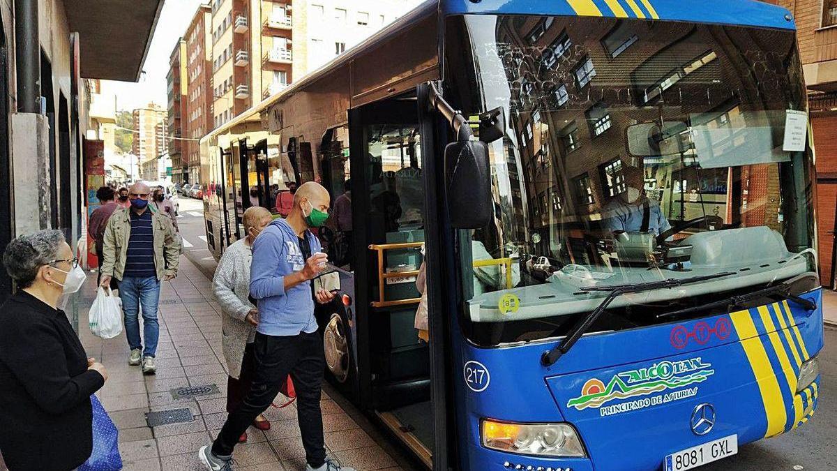 Viajeros accediendo al autobús en Langreo.