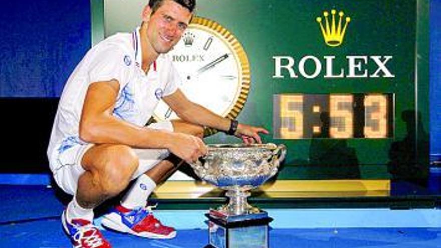Djokovic posa con su trofeo ante el reloj con el tiempo de la final. | reuters