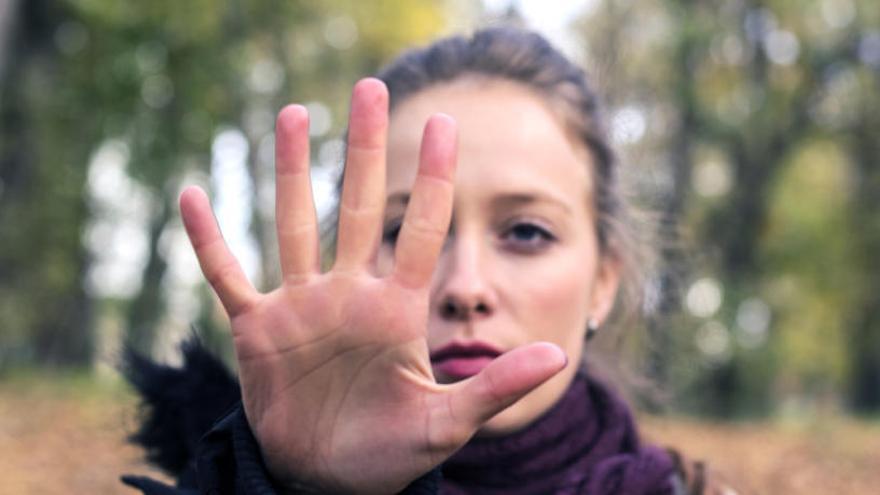 Una mujer realiza un gesto con la mano a la cámara.