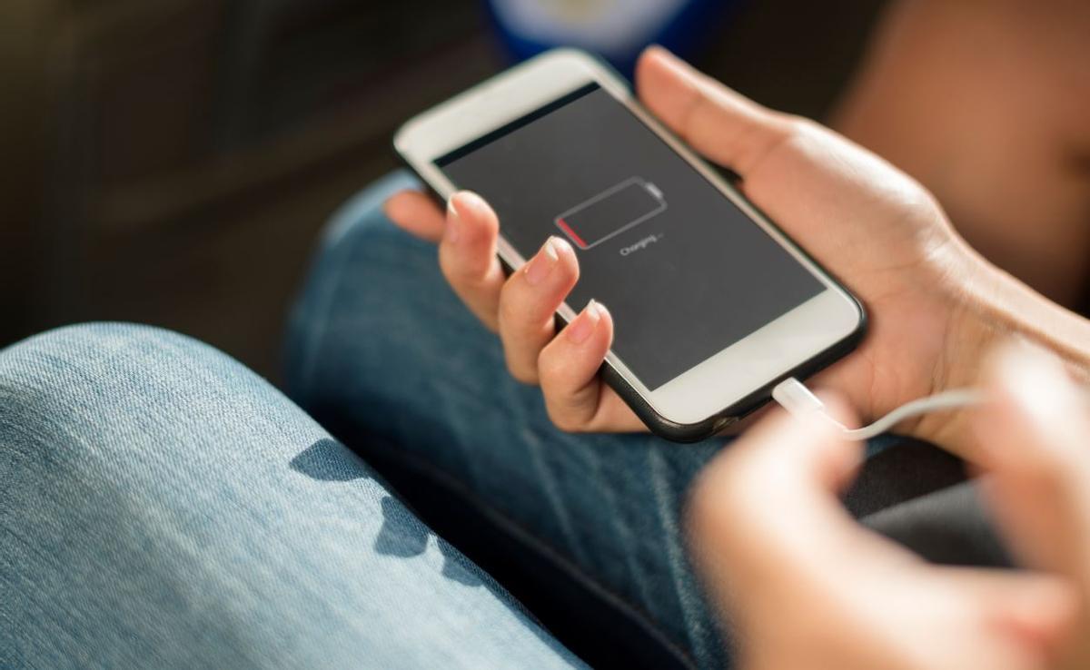 Persona carregant un mòbil.