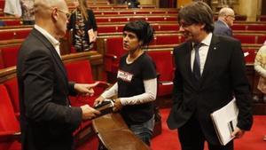 Carles Puigdemont observa a la diputada de la CUP Anna Gabriel y al ’conseller’ Romeva, en el Parlament.