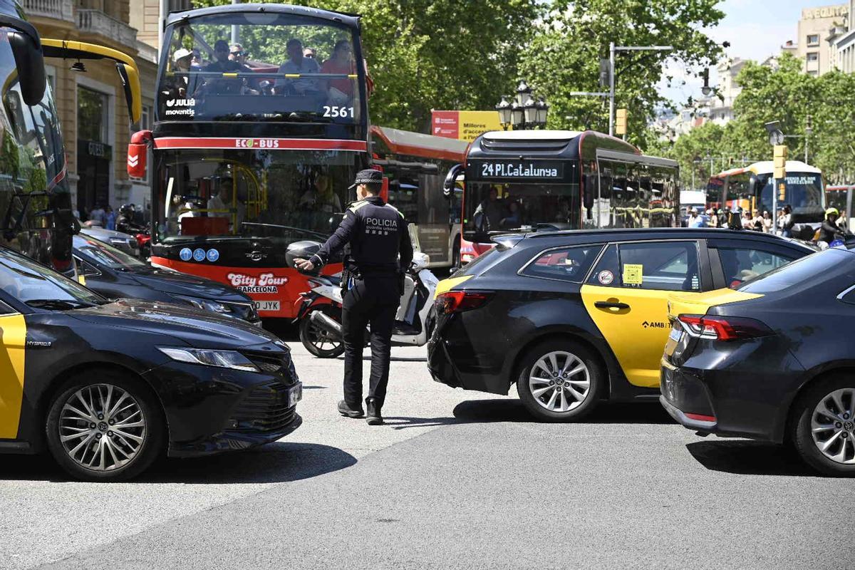 Guardia urbana regulando el caótico tráfico en gran vía con paseo de gracia