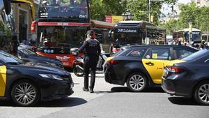 Guardia urbana regulando el caótico tráfico en gran vía con paseo de gracia