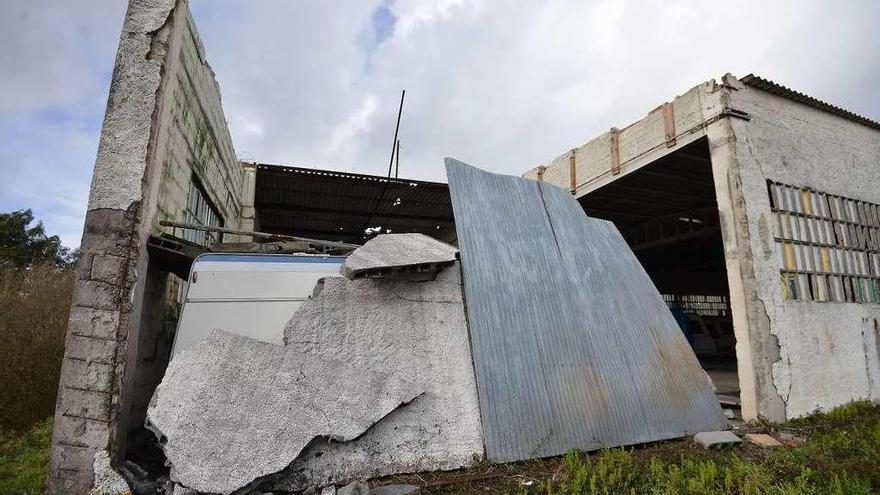 El viento derribó un muro y buena parte del tejado de una nave empresarial en el lugar de Adina. // G. S.