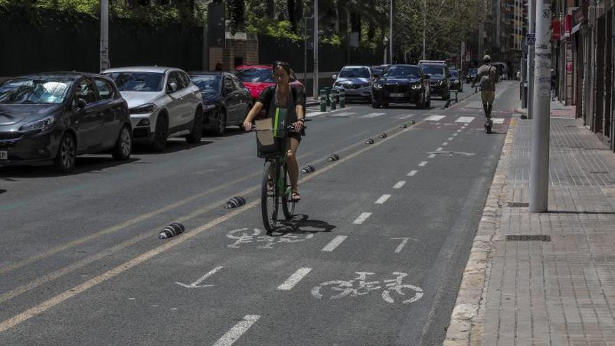 Una ciclista y un patinete circulan por el carril bici de la calle Juan Carlos I. | ANTONIO AMORÓS