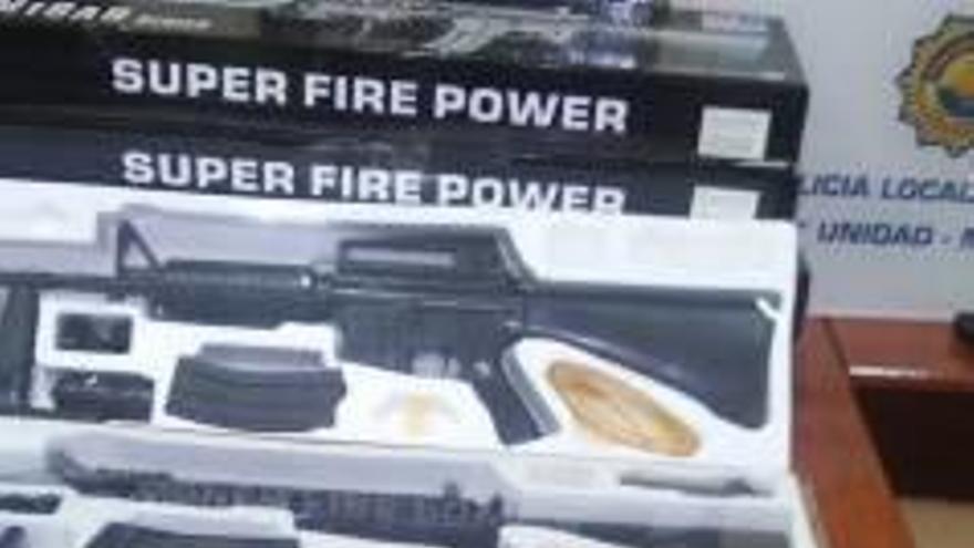 Armas simuladas y placas de policía como premio en un puesto de la feria de Valencia