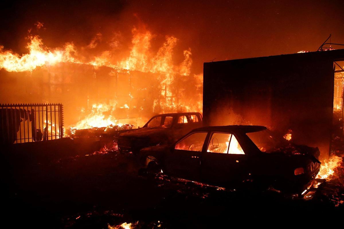 Vehículos y casas arden durante un incendio en Viña del Mar, Chile, el 2 de febrero de 2024. Una enorme nube de humo en forma de hongo se cierne sobre las zonas turísticas del centro de Chile, incluidas Viña del Mar y Valparaíso, donde estalló un incendio forestal el viernes. amenazando cientos de viviendas y obligando a la evacuación de los residentes