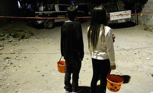 Dos nens vestits per celebrar Halloween observen l’escenari d’un crim a Ciudad Juárez, Mèxic.