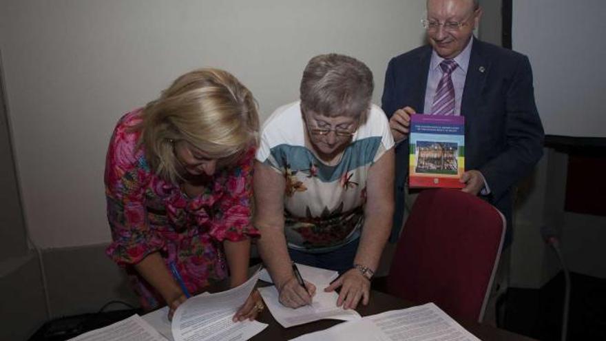 Covadonga Vigil, directora de la Escuela de Turismo de Asturias, y Carmen Arango, alcaldesa de Muros, firman su  adhesión a la declaración del derecho a la paz junto a Carlos Villán en San Esteban de Pravia.