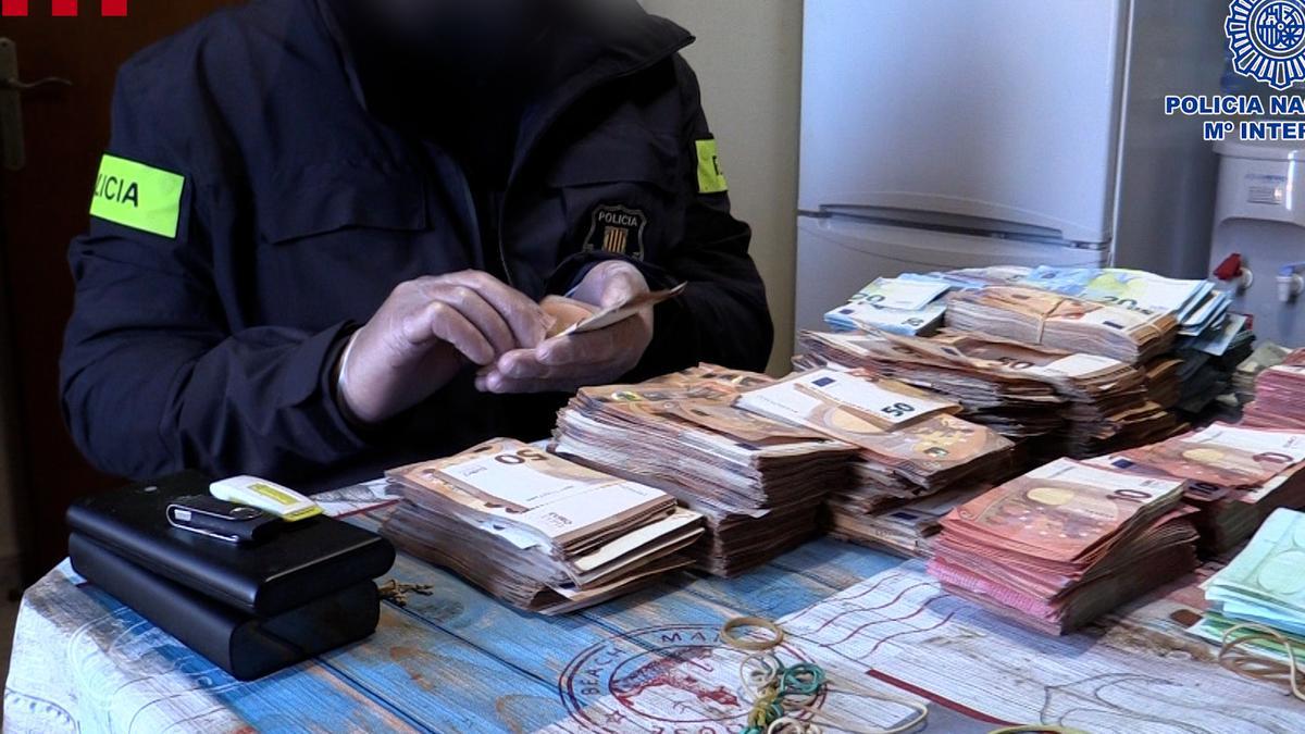 La policia amb diners localitzats durant els escorcolls en el marc del macrooperatiu