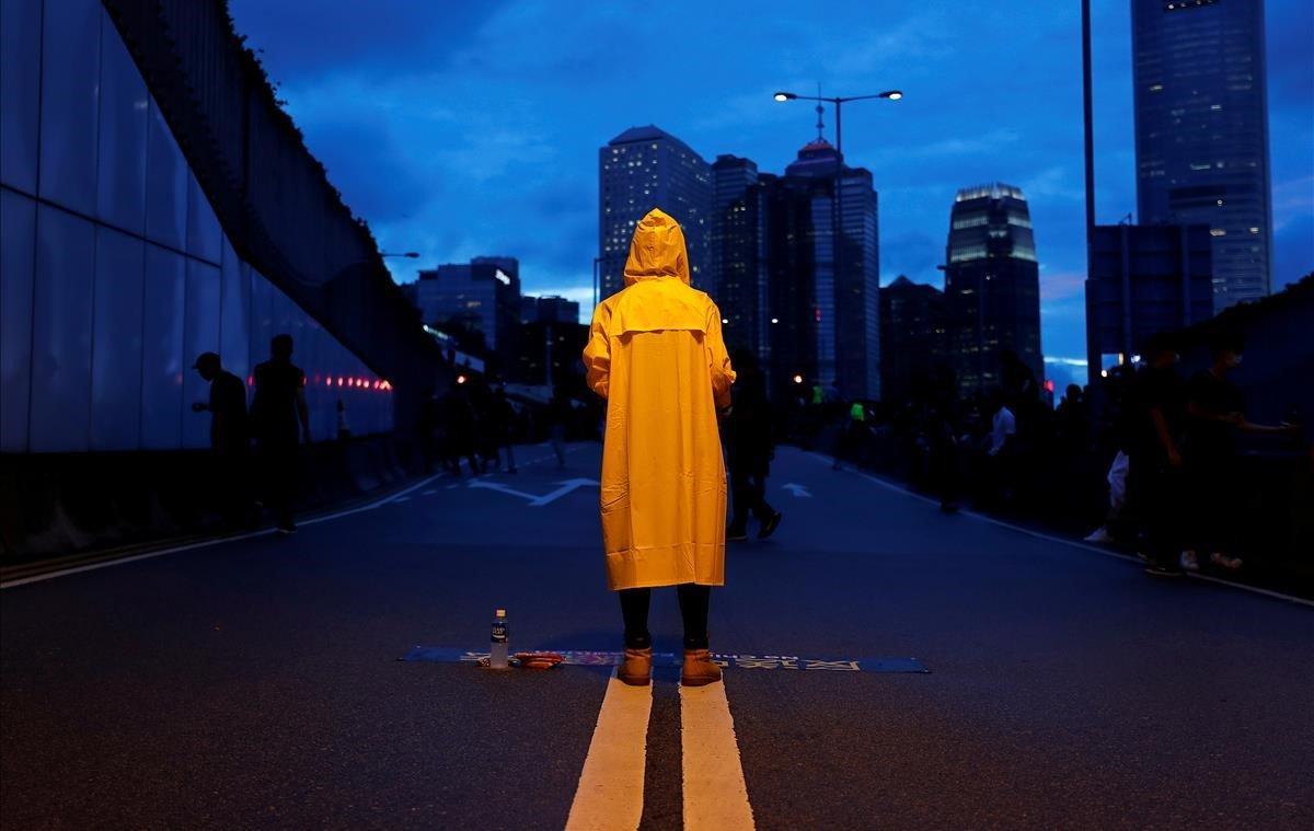 Un manifestante usa un impermeable amarillo para rendir homenaje a un hombre que murió tras caerse de un andamio en el complejo Pacific Place mientras protestaba contra el proyecto de ley de extradición, durante una manifestación que exigía a los líderes de Hong Kong que renuncien y retiren el proyecto de ley de extradición en Hong Kong.