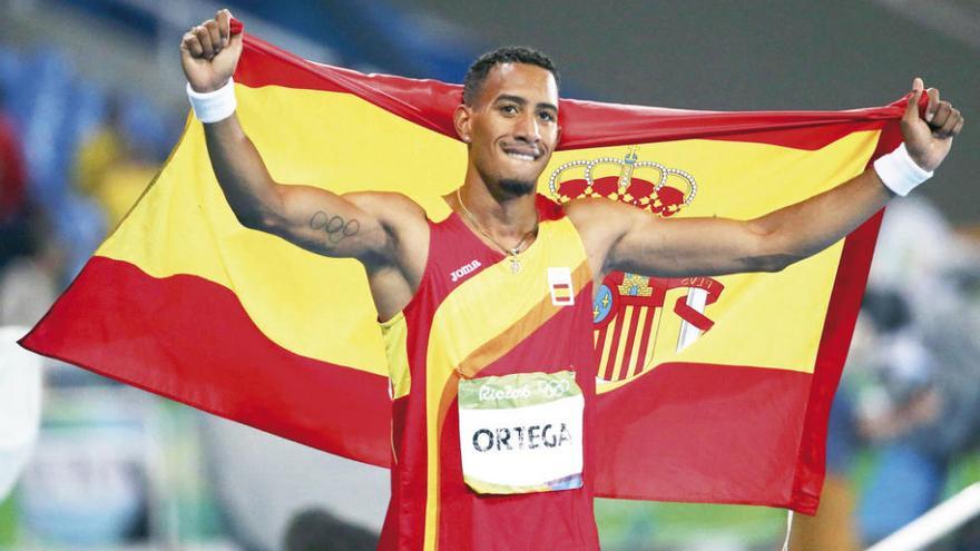 Ortega celebra su medalla con la bandera de España. // Reuters