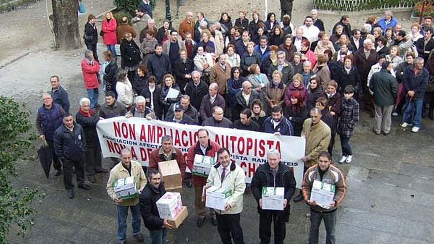 Los afectados con las cajas de las alegaciones, ayer, concentrados ante el Concello de Redondela