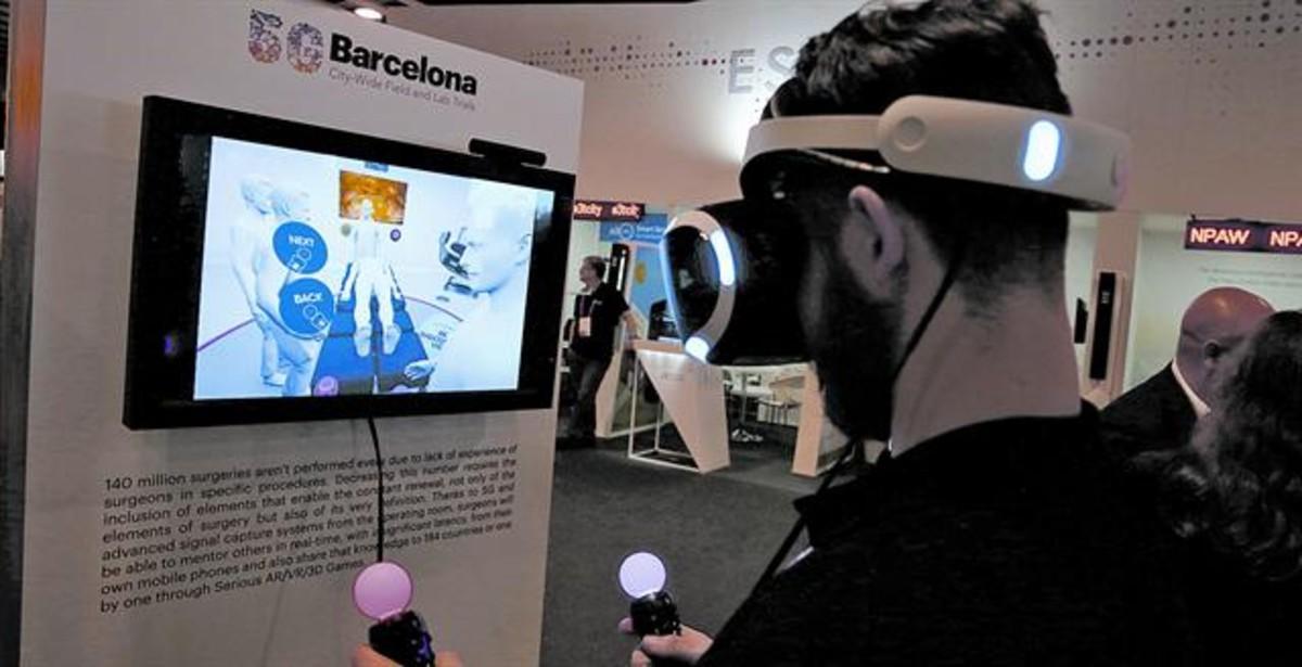 Un visitante del MWC simula participar en una operación a distancia con ayuda de la tecnología 5G, el miércoles en el MWC.