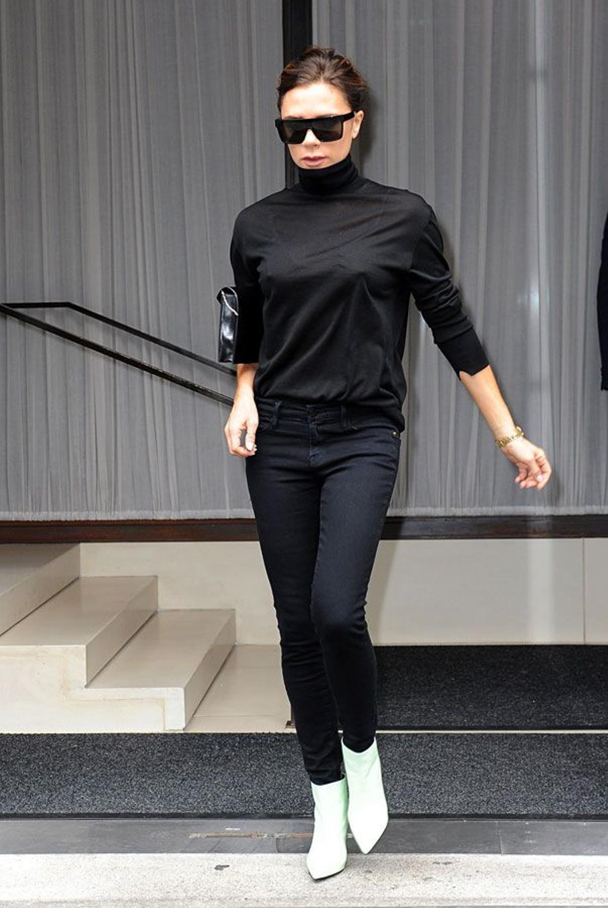 Victoria Beckham con look negro y botines blancos