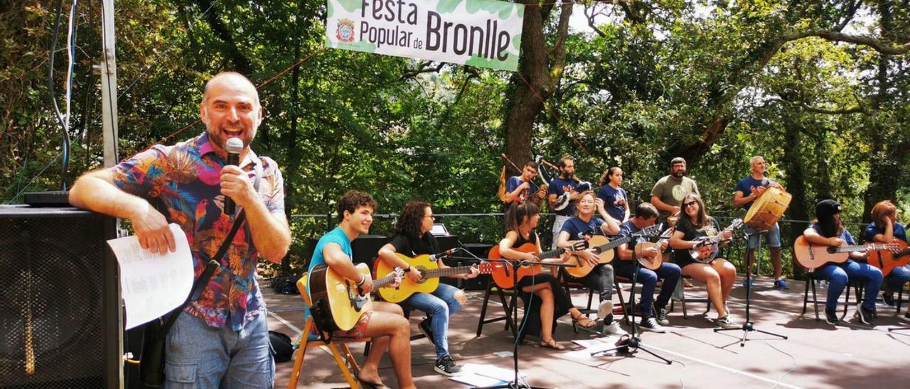 Una de las actuaciones musicales en medio de los vecinos comiendo bajo la carballeira de Bronlle.   | // G.N.