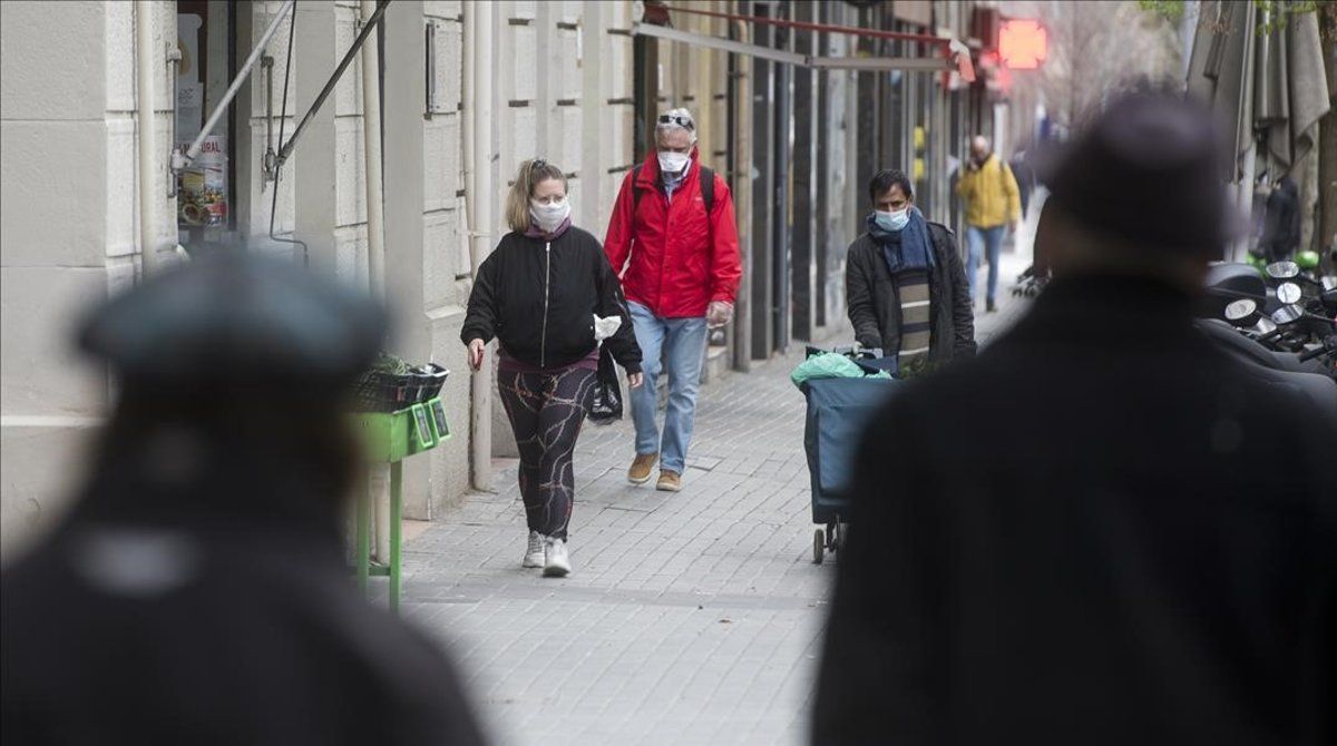 coronavirus. Gente con mascarilla por las calles de Barcelona