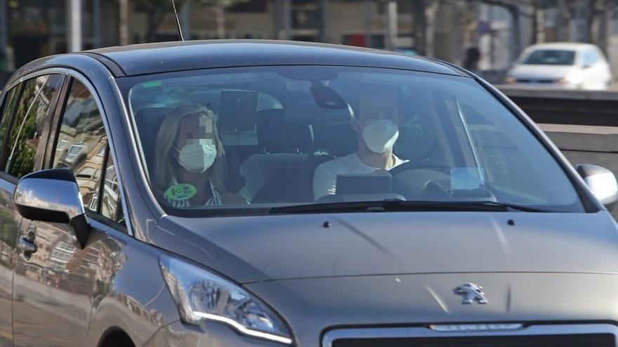 Dos personas haciendo uso de la mascarilla dentro del coche / Marta G. Brea