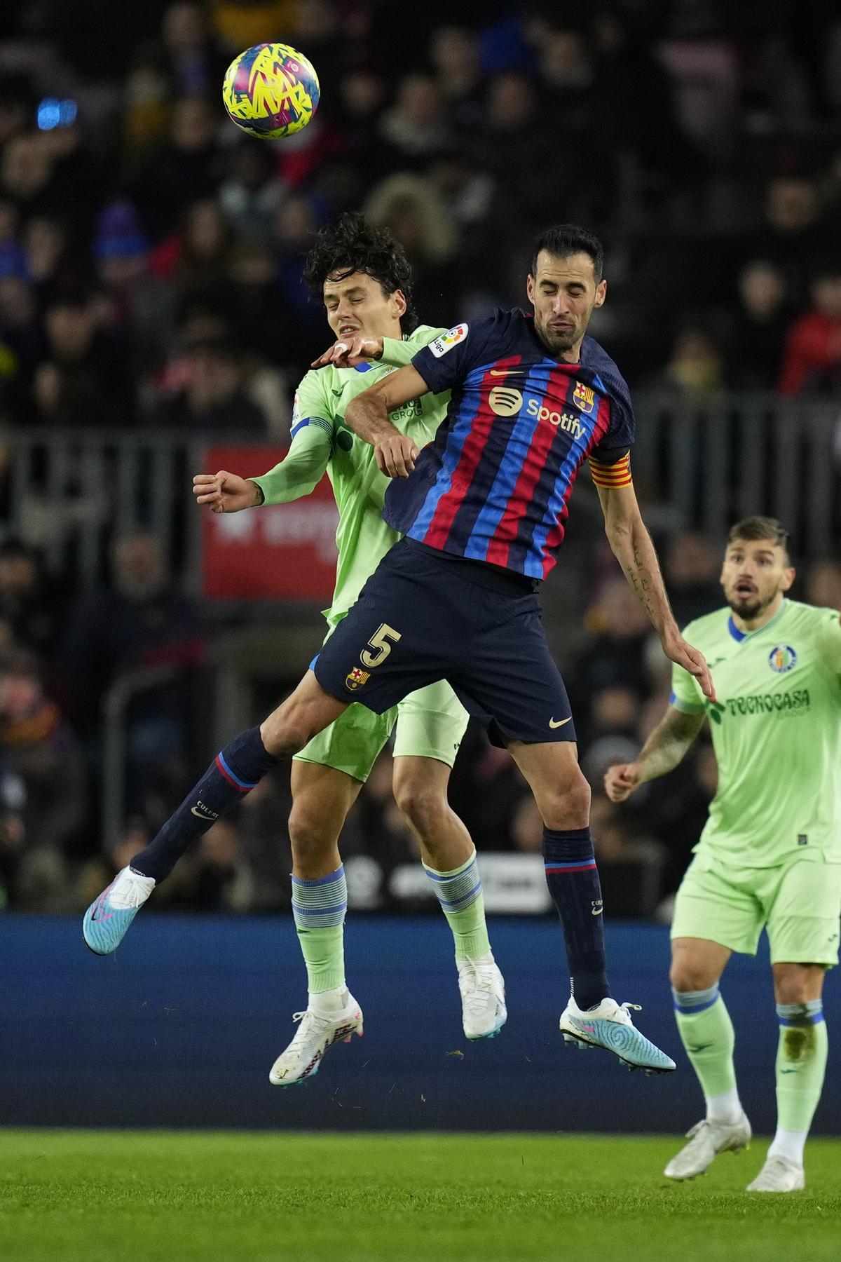 BARCELONA, 22/01/2023.- El centrocampista del Barcelona Sergi Busquets (d) salta a por un balón con Enes Ünal, del Getafe, durante el partido de Liga en Primera División que FC Barcelona y Getafe CF disputan este domingo en el Camp Nou. EFE/Siu Wu