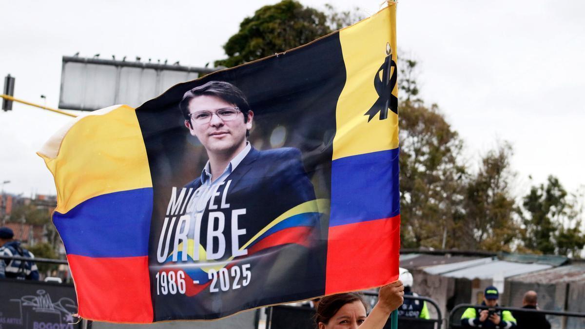 Una bandera colombiana con crespón negro y el rostro del asesinado Miguel Uribe.