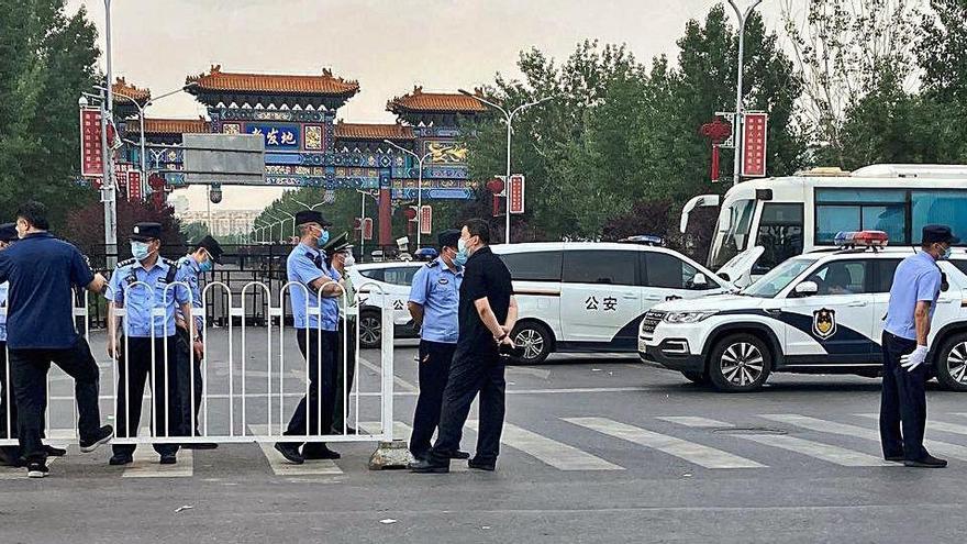 Policies de Pequín tancant el mercat on s&#039;ha detectat el nou brot.