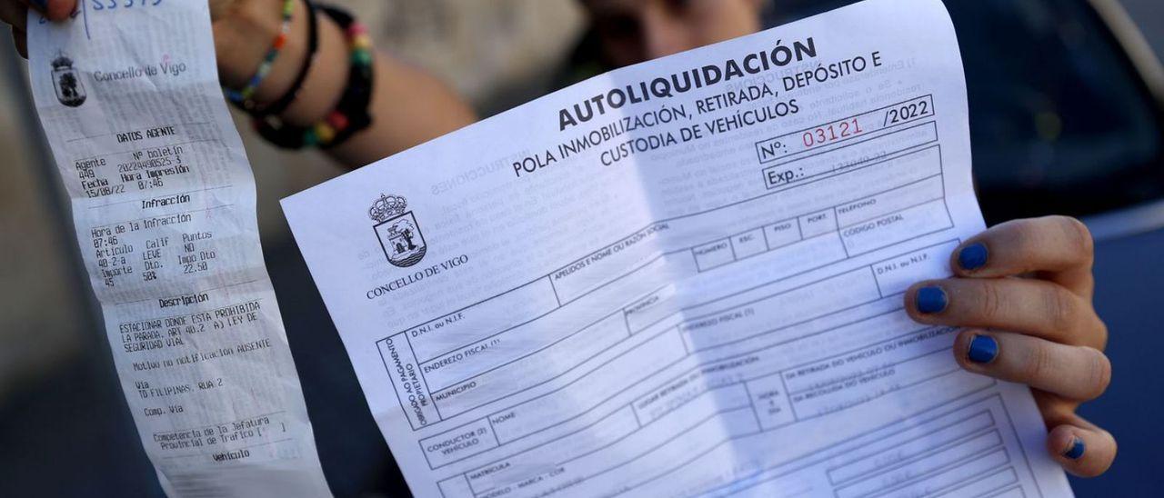 Una vecina con la multa y la liquidación que tuvo que pagar para sacar su coche del depósito. /  JOSÉ LORES