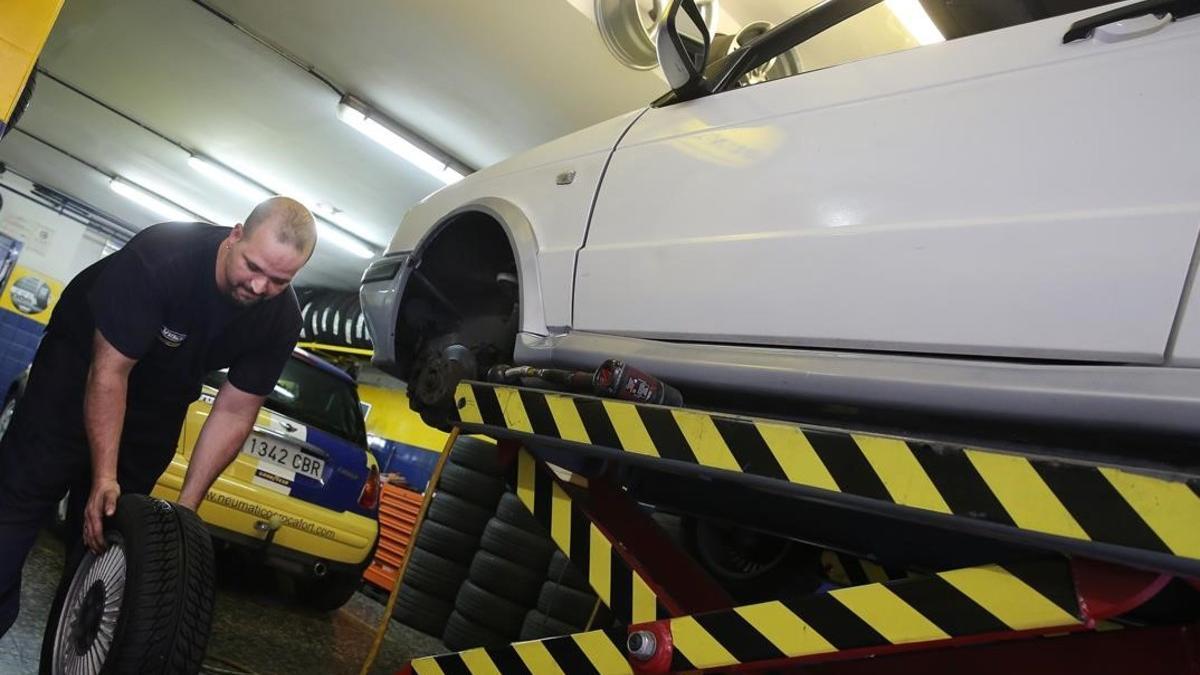Un mecánico trabaja en un coche en un taller de Barcelona.
