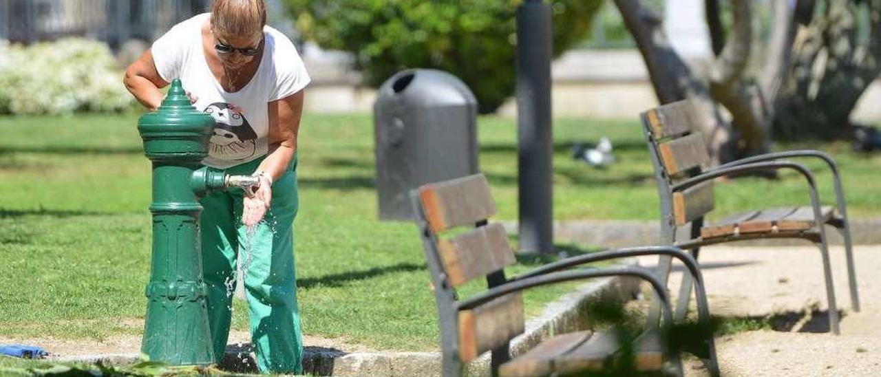 Una mujer se refresca por las altas temperaturas del pasado mes. // G. Santos